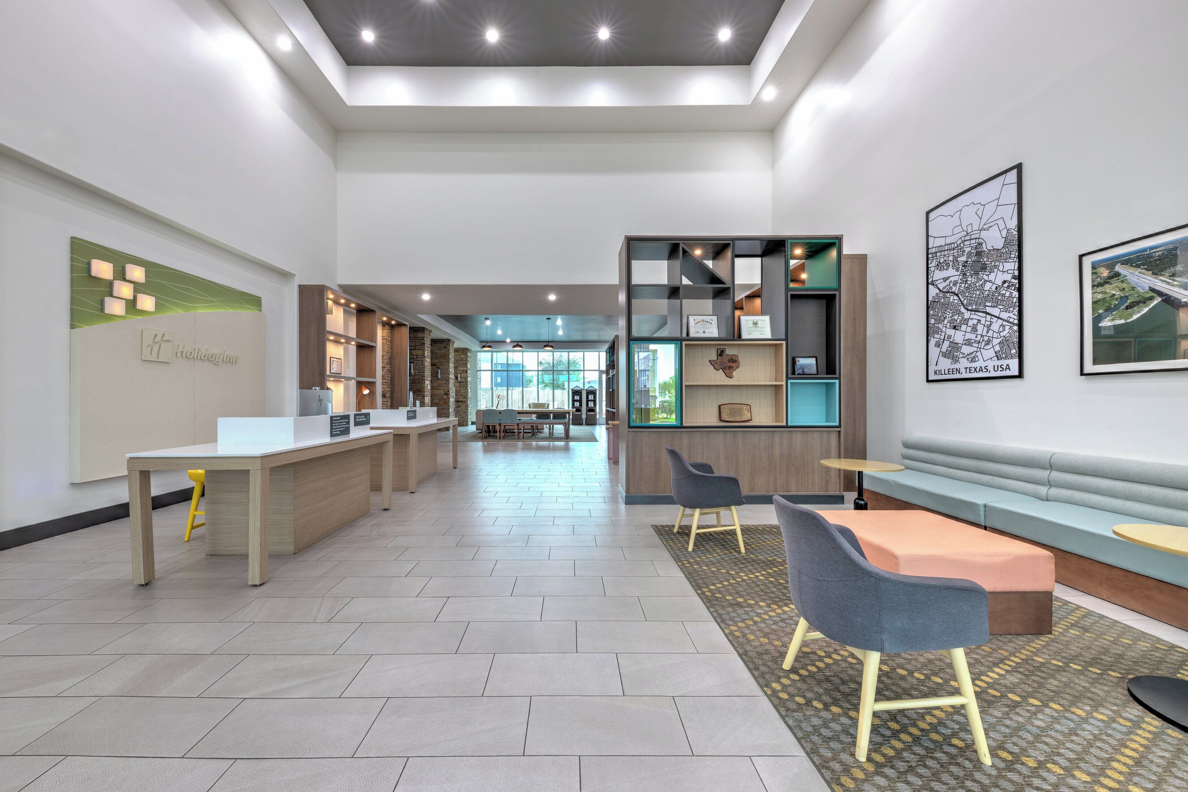 Eine moderne Hotellobby mit Empfangstresen, Sitzgelegenheiten und Blick auf die Stadtlandschaft.