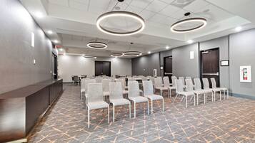 A conference room with a long table, multiple chairs, and a podium.