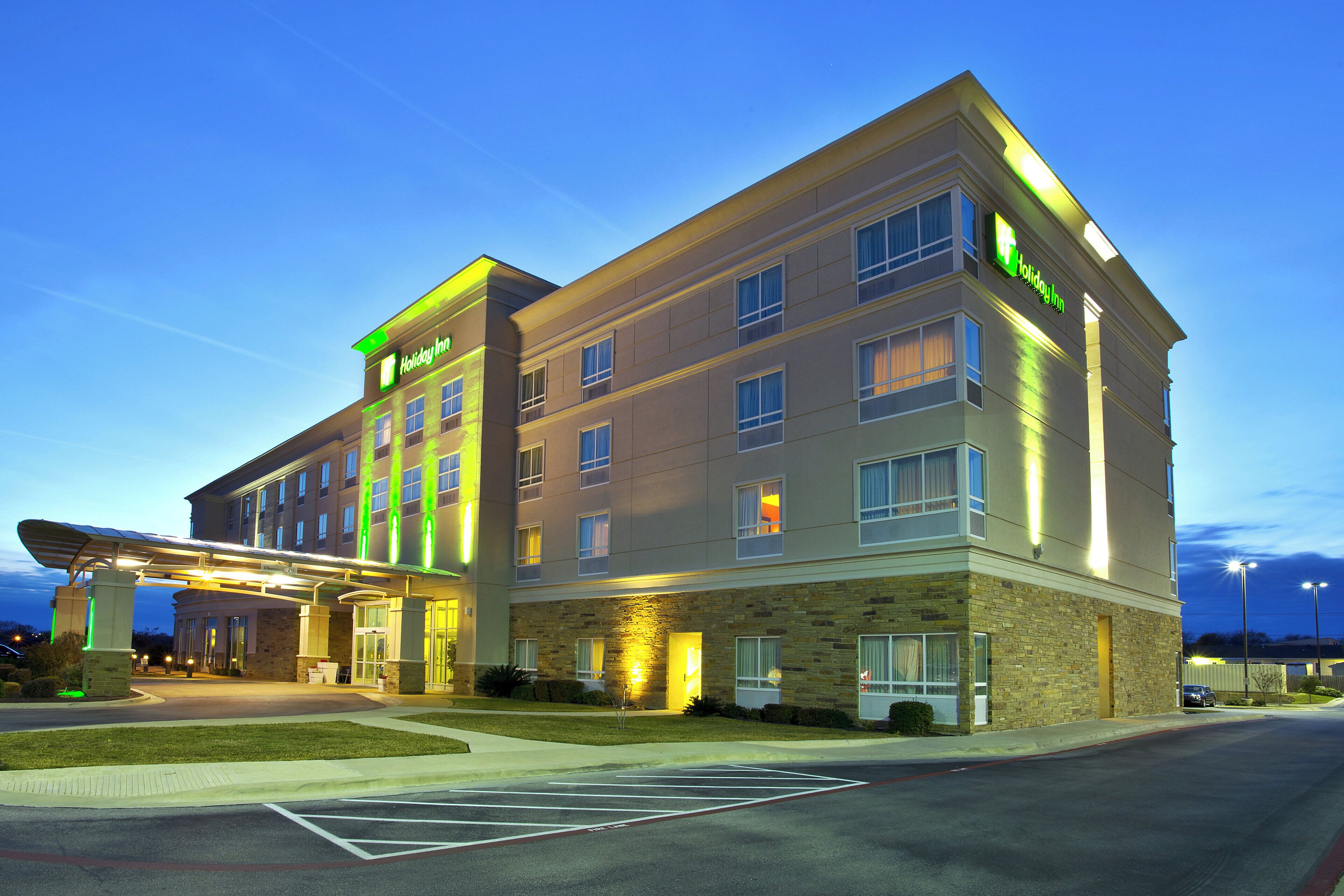 A Holiday Inn hotel with a covered entrance, multiple floors, and a parking lot.