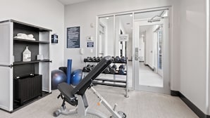 A gym with exercise equipment, a rack of dumbbells, and a wall-mounted sign. - Holiday Inn Killeen – Fort Hood Area by IHG (Killeen)