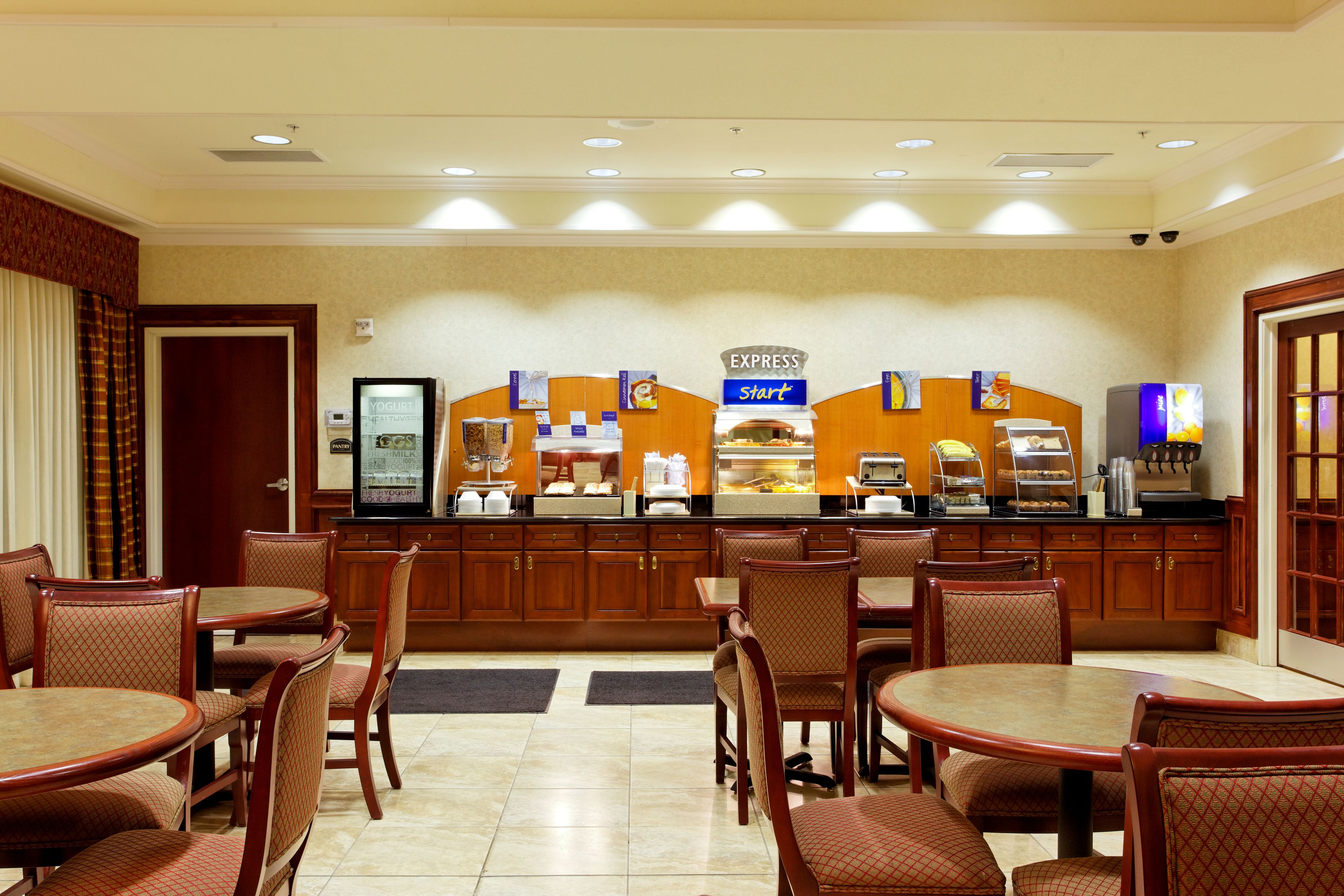 Een ontbijtruimte van een hotel met houten meubels, een buffet en een bord dat de snelle startservice aangeeft.