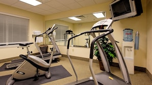 A gym with treadmills, a stationary bike, and a water dispenser. - Holiday Inn Express Hotel & Suites San Antonio by IHG (San Antonio)