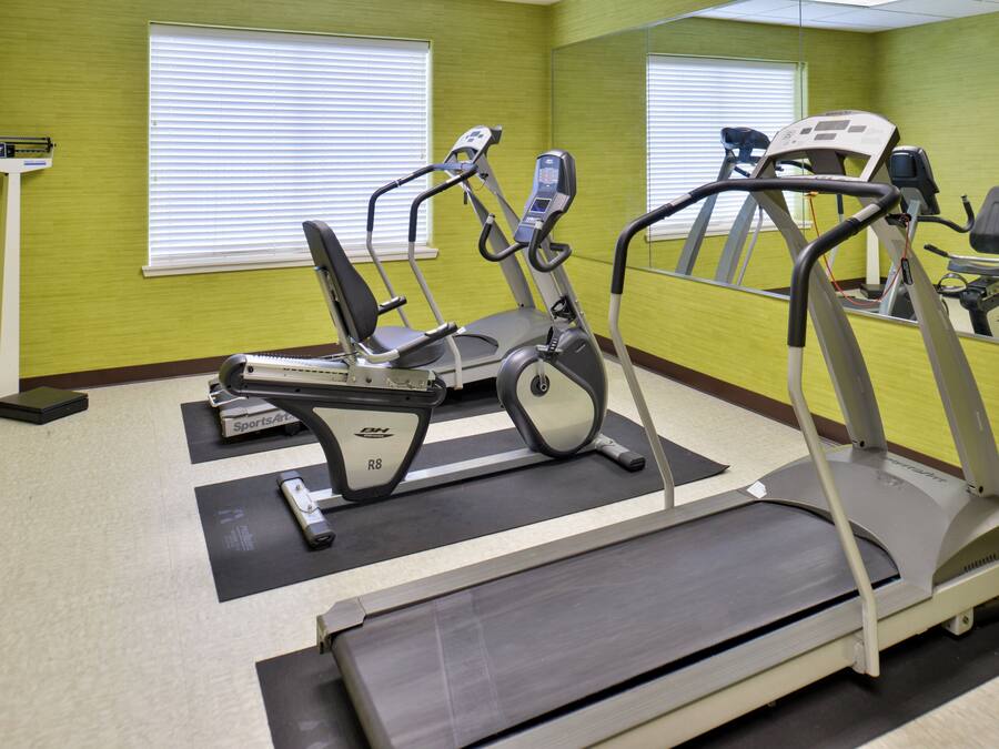 A fitness room with treadmills, a stationary bike, and a rowing machine.