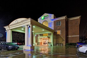 Un hôtel Holiday Inn Express & Suites doté d’une entrée couverte, d’une façade en briques et d’un parking.