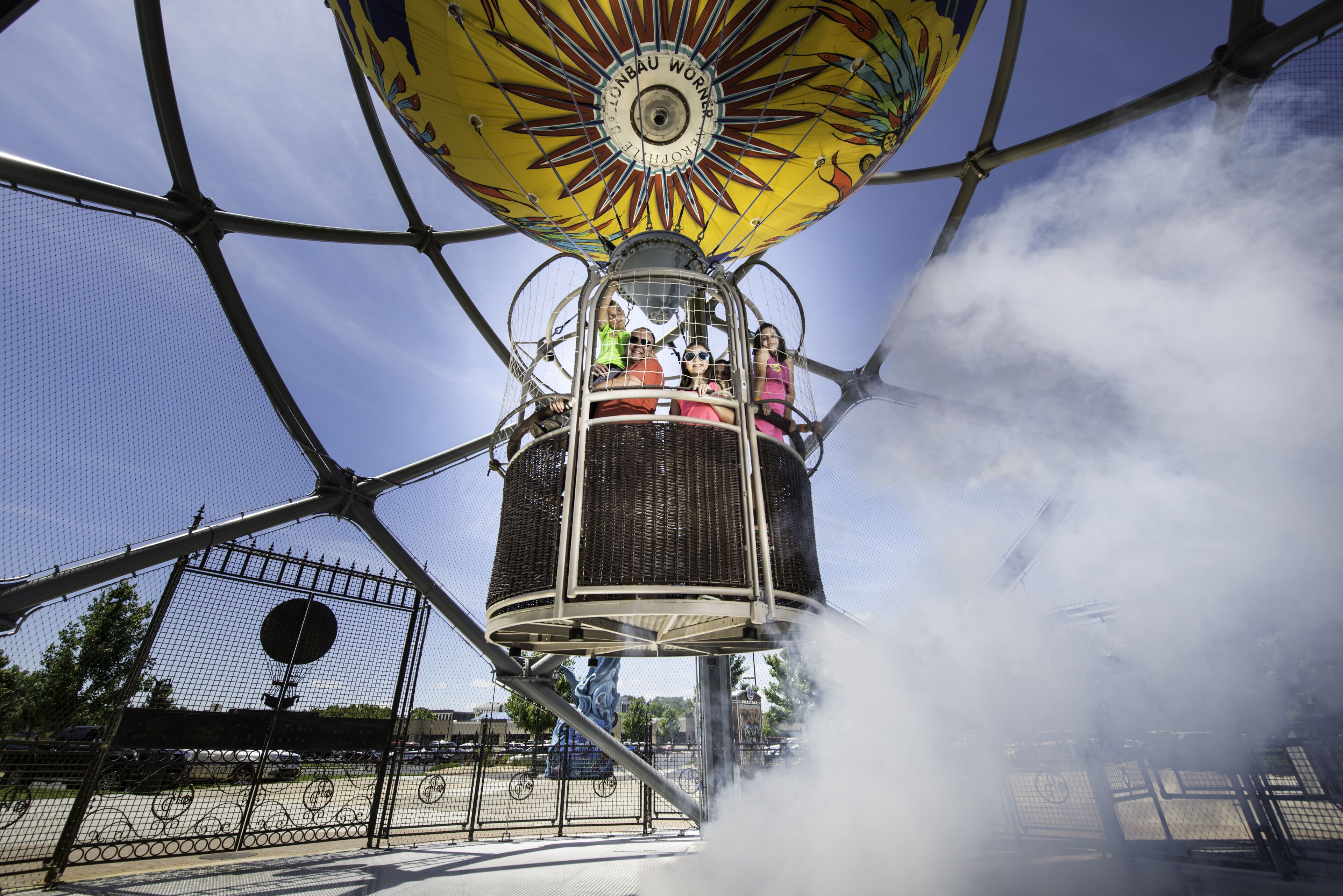 A ride with a sun-like canopy, a cage-like structure, and a misty environment.