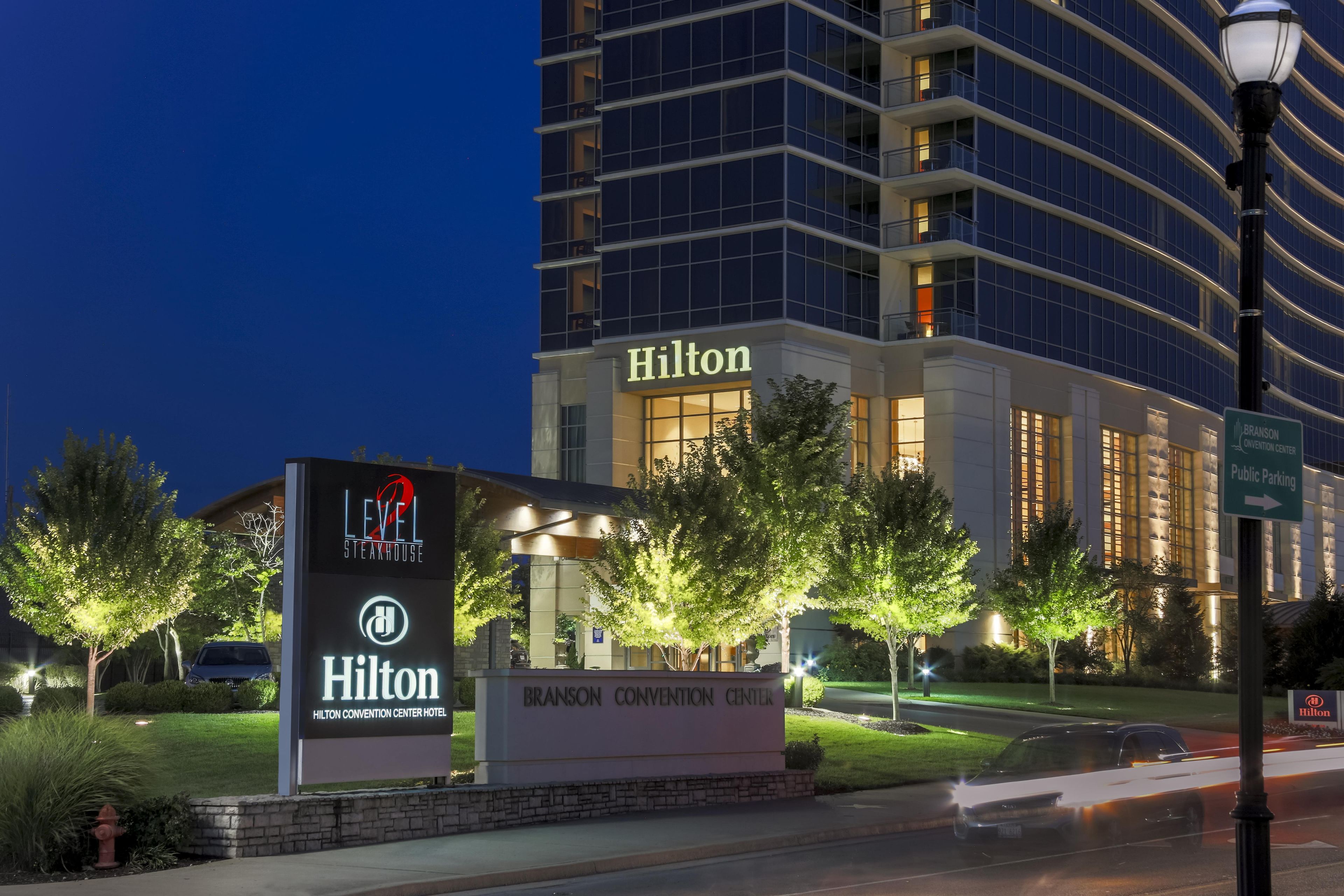 Un edificio de la marca Hilton con un letrero que indica Level 2 Steakhouse y Hotel Centro de Convenciones Hilton.