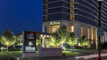 Un edificio de la marca Hilton con un letrero que indica Level 2 Steakhouse y Hotel Centro de Convenciones Hilton.