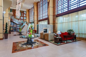A spacious lobby with a grand staircase, a fireplace, and modern furnishings. - Hilton Branson Convention Center (Branson)