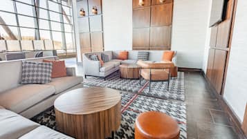 A modern living room with a sectional sofa, round coffee table, and a patterned rug.