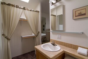 A bathroom with a sink, mirror, and towel rack. - Arden Acres Executive Suites and Cottages (Sacramento)