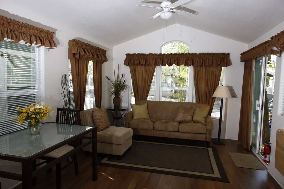 A living room with a sofa, a glass coffee table, and a dining table with chairs.