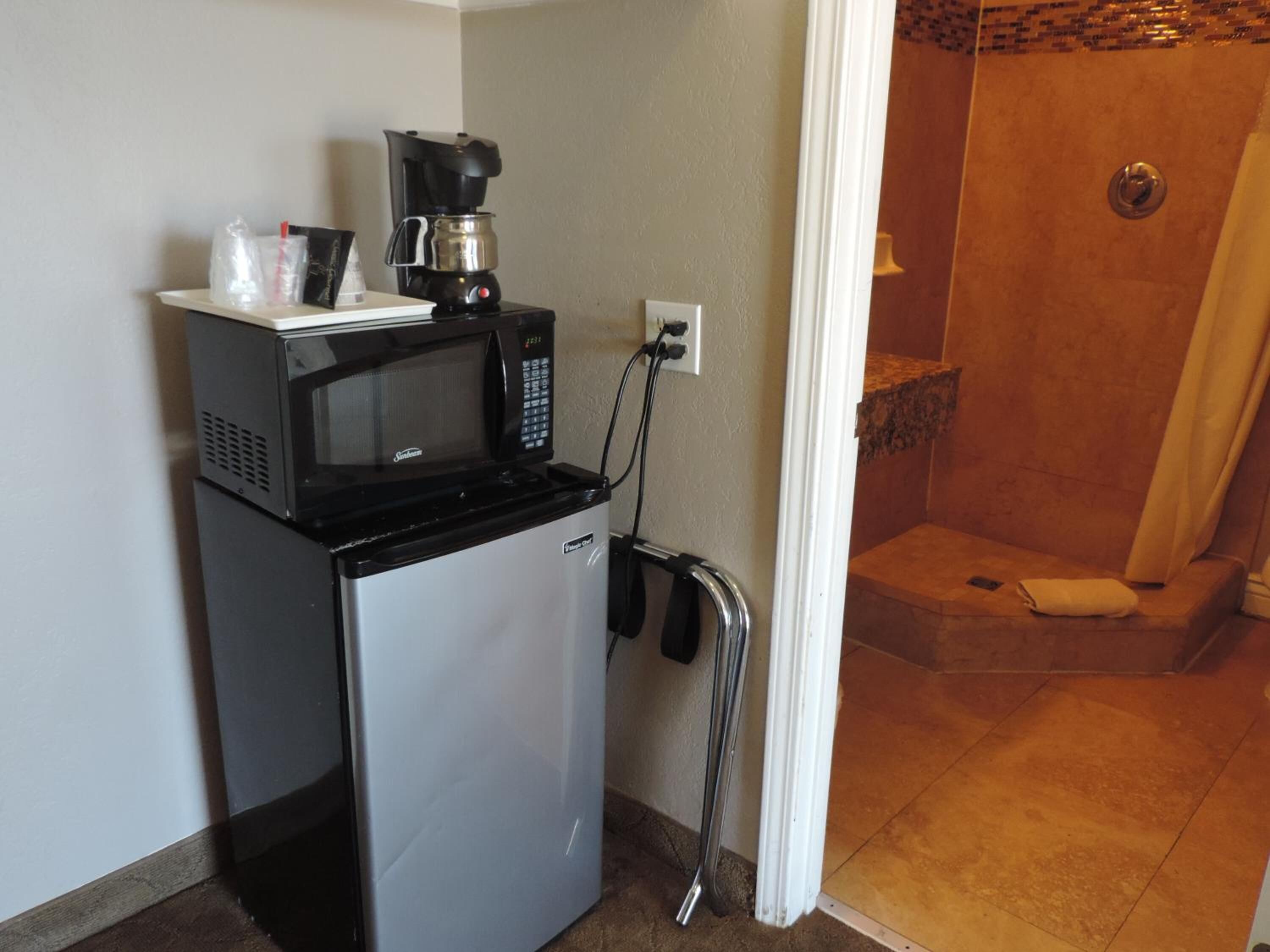 A compact kitchenette with a microwave, coffee maker, and a small refrigerator.