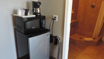 A compact kitchenette with a microwave, coffee maker, and a small refrigerator.