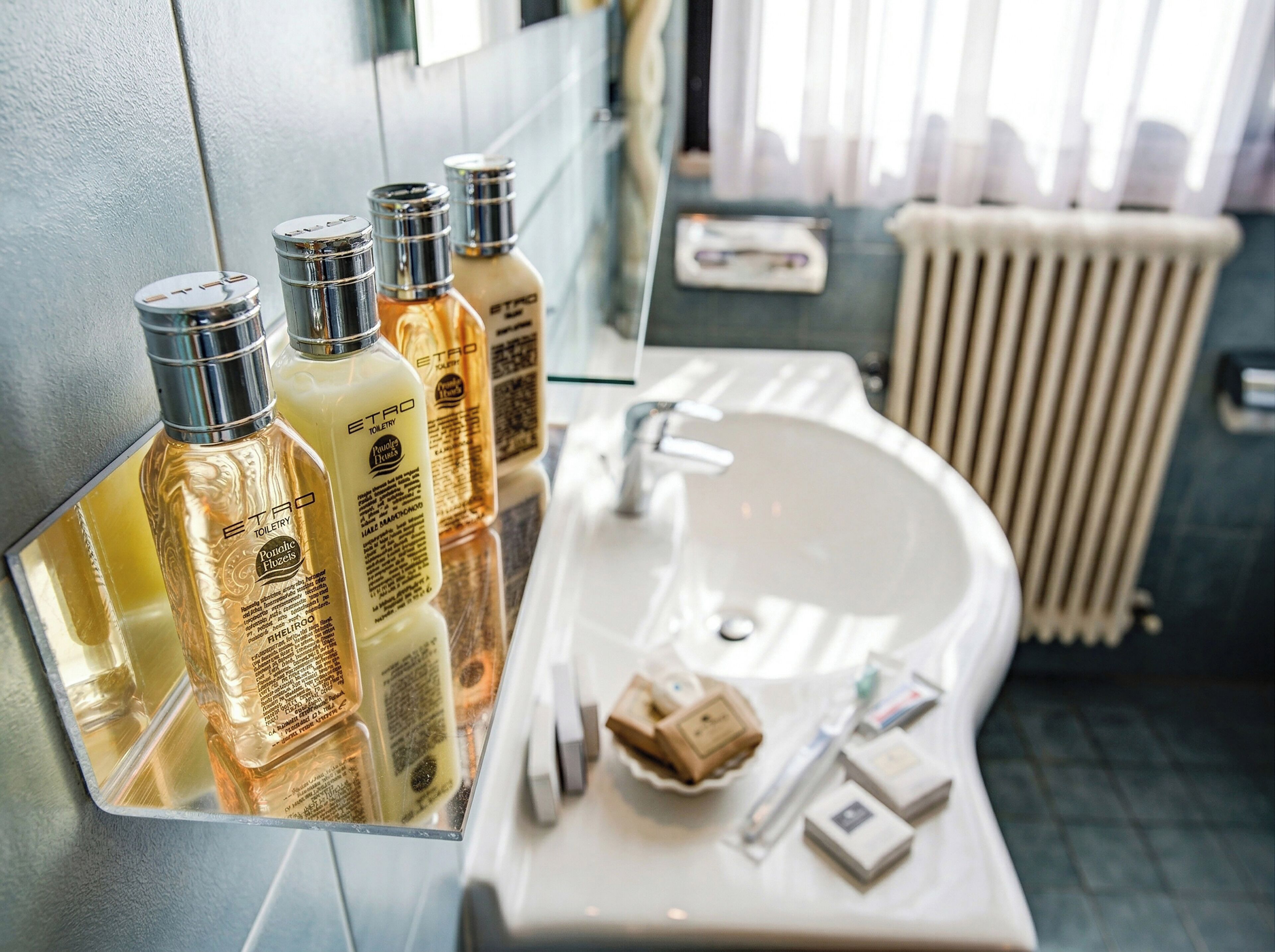 A bathroom with a mirror, toiletries, and a sink.