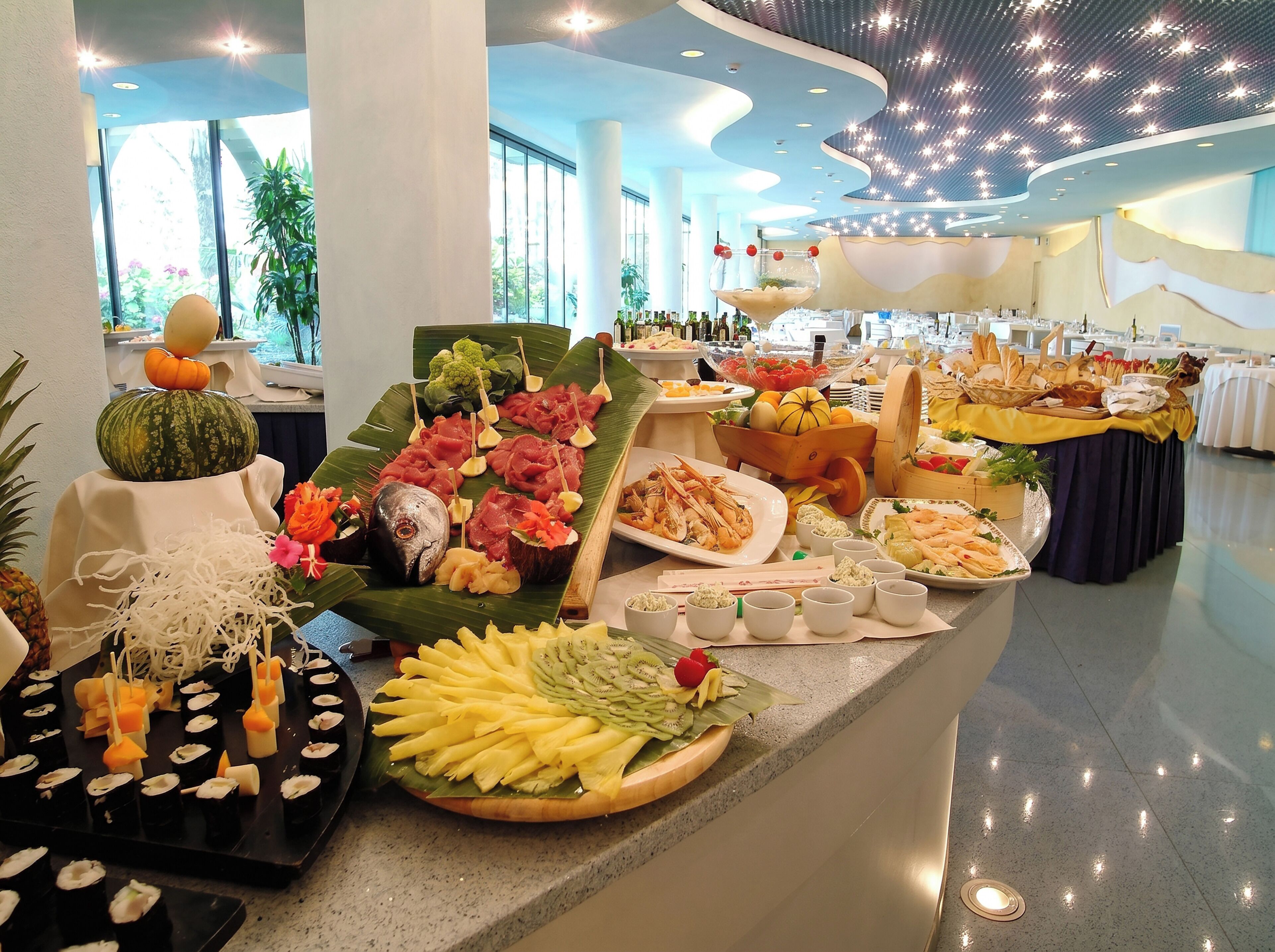 A buffet with various food items, including sushi, fruits, and seafood.