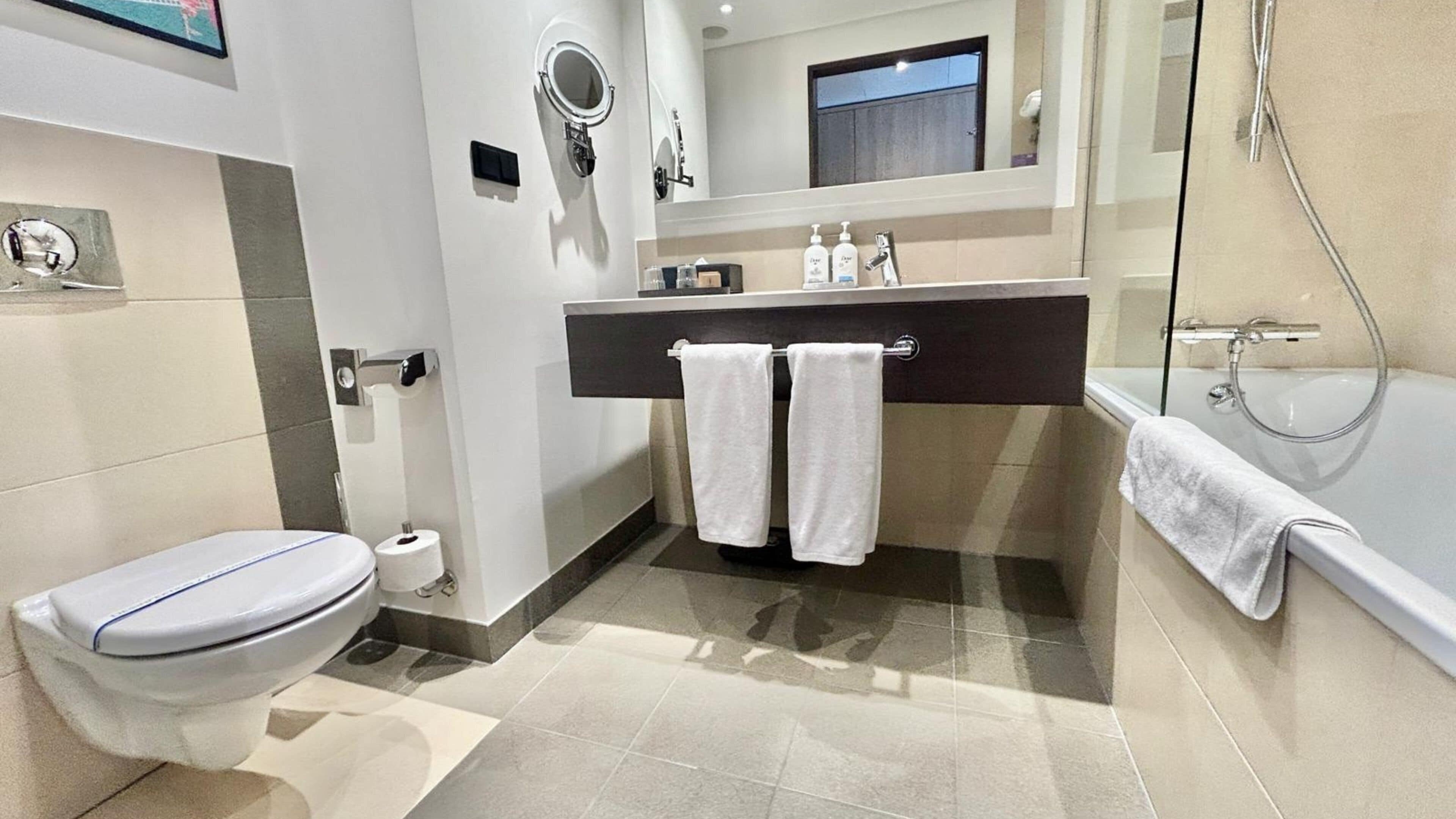 A modern bathroom with a toilet, sink, and shower.