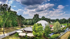 A park with a large white dome, picnic tables, and a walking path. - Holiday Inn Resort Warszawa Józefów**** by IHG (Jozefow)