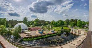 A park with a large dome structure, a basketball court, a playground, and a pond. - Holiday Inn Resort Warszawa Józefów**** by IHG (Jozefow)