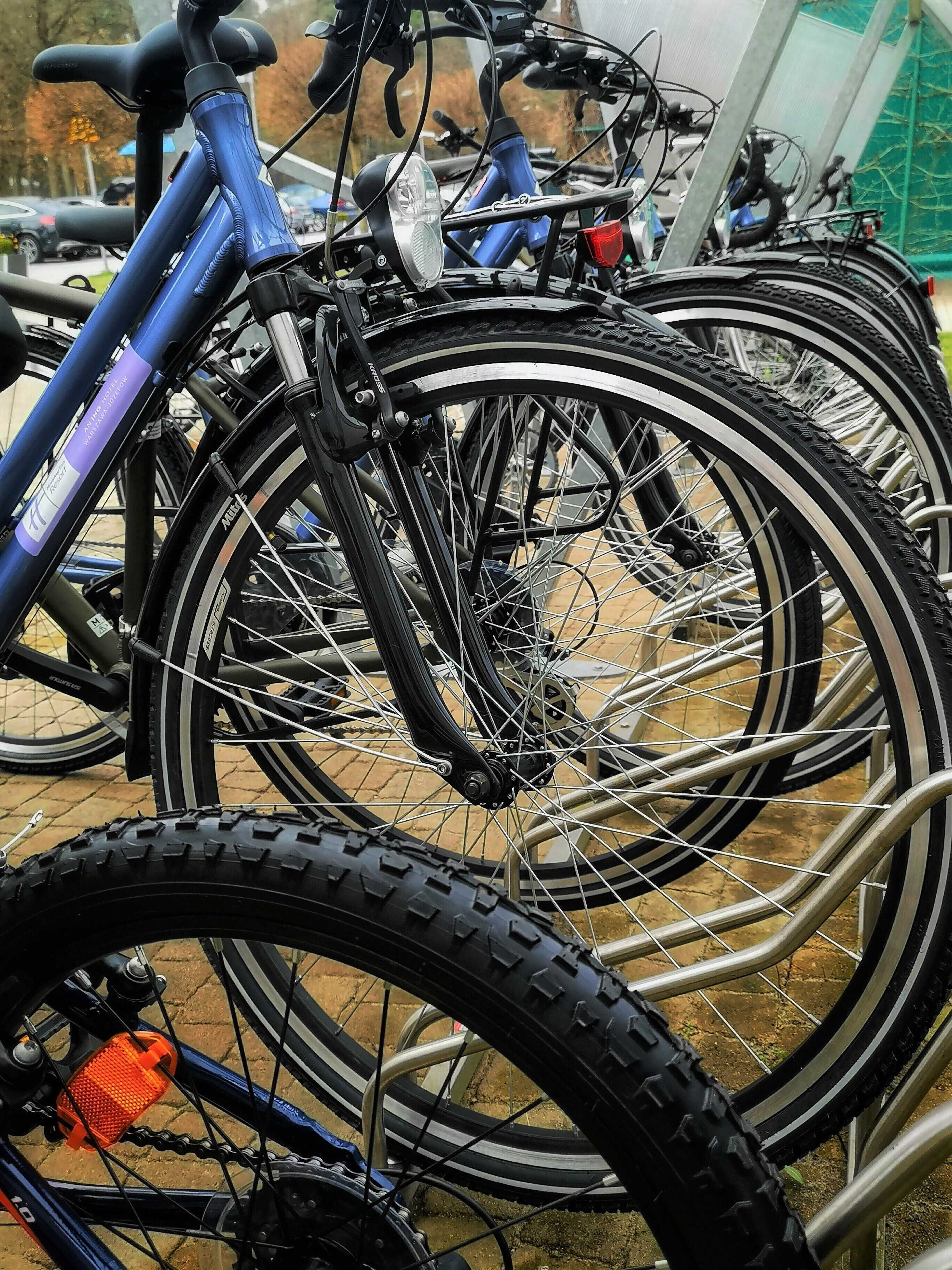 Varias bicicletas estacionadas en un área techada con un soporte metálico.