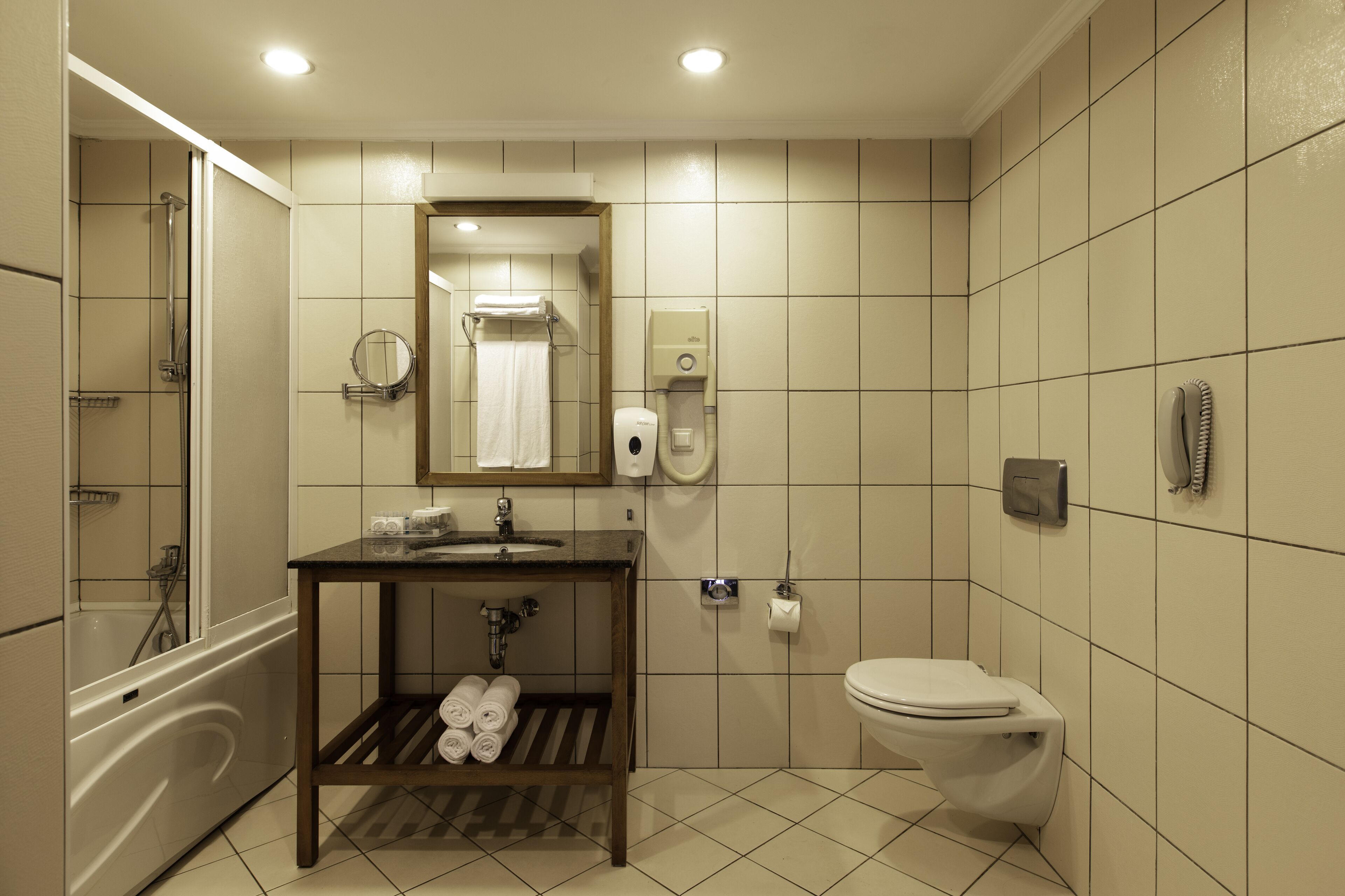 Un bagno con vasca, WC, lavandino e specchio.