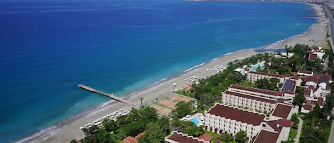 Pantai pribadi, kursi berjemur, payung pantai, dan handuk pantai