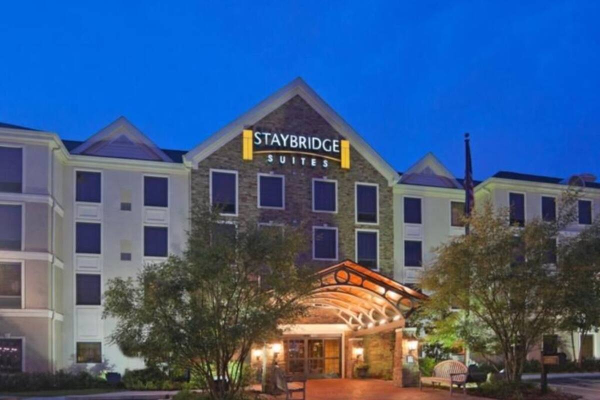 Un hôtel Staybridge Suites doté d’une entrée imposante et d’une enseigne au-dessus du bâtiment principal.