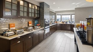 Een moderne keuken met een buffetopstelling, waaronder een koffiehoek en diverse etenswaren.