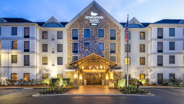 Een hotel met een stenen gevel, een opvallende entree met een dak, en een Amerikaanse vlag.