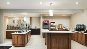 A modern kitchen with wooden cabinets, a central island, and a Coca-Cola refrigerator. - Staybridge Suites Durham/Chapel Hill by IHG (Durham)