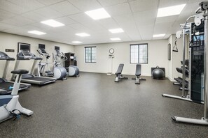 A gym with treadmills, elliptical machines, a bench, and weightlifting equipment. - Staybridge Suites Durham/Chapel Hill by IHG (Durham)
