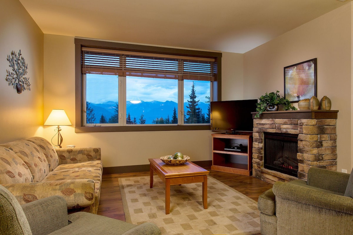 A living room with a fireplace, a sofa, a coffee table, and a TV.