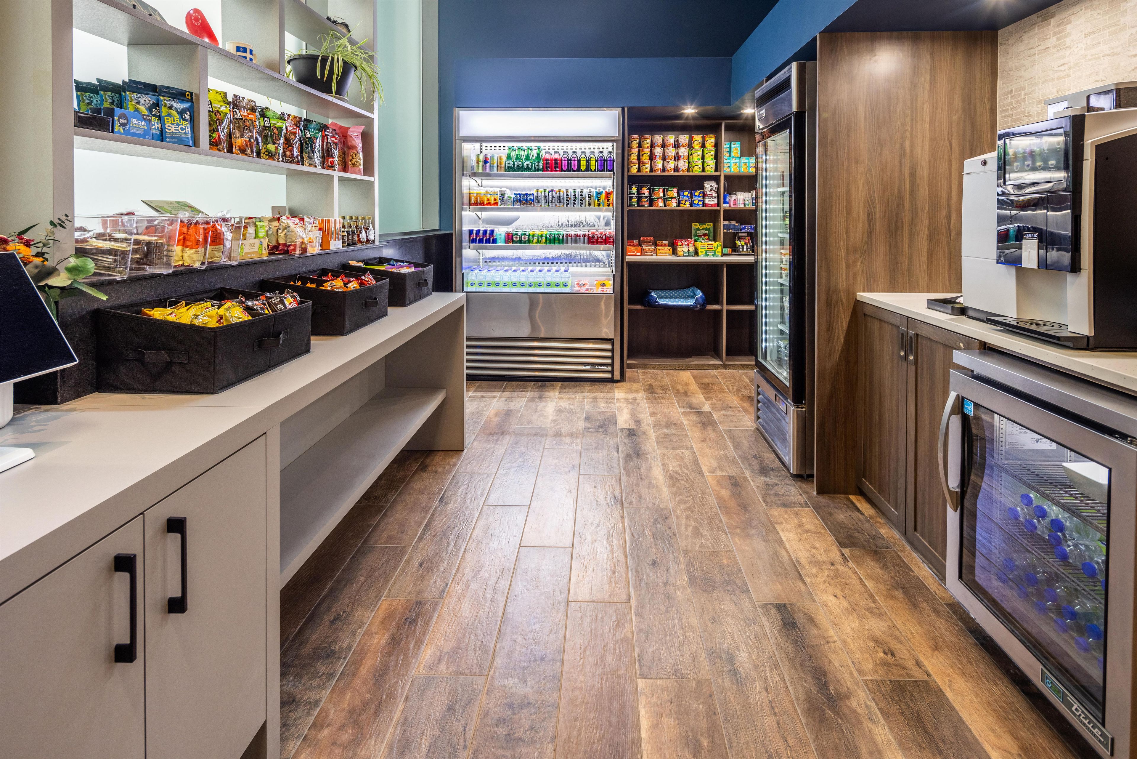 Un espacio moderno para comidas y bebidas con una variedad de bocadillos, refrescos y una máquina de café.