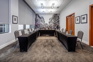A conference room with a long table, chairs, and framed pictures on the walls. - Embassy Suites Montréal by Hilton (Montreal)