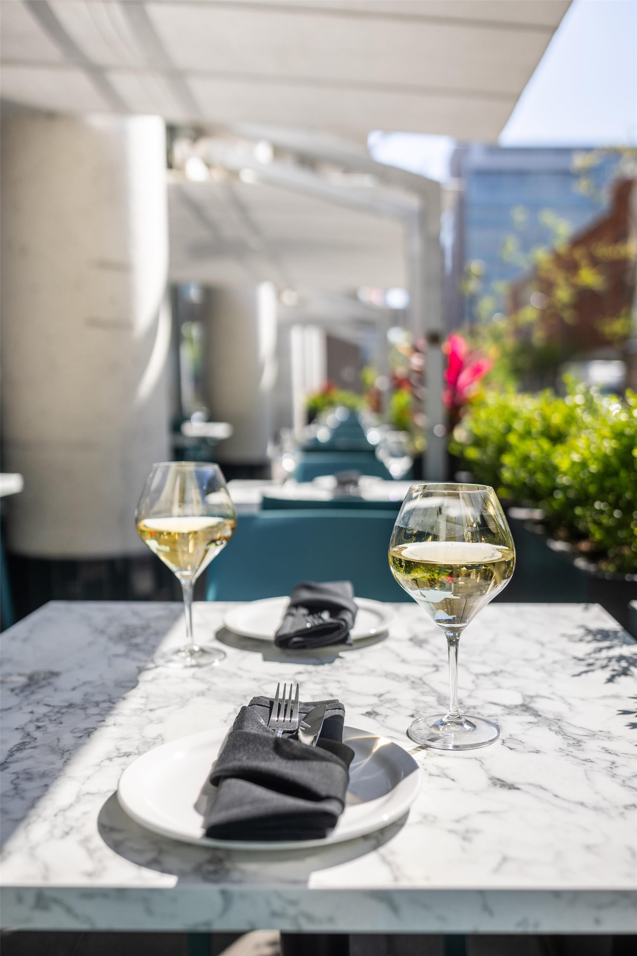 A dining table with two wine glasses and a folded napkin.