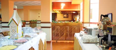 A buffet setup with various food items and a coffee station.