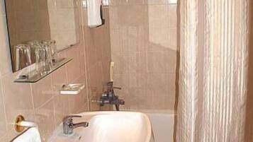 Un baño con lavamanos, espejo y cortina de ducha.