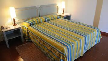 A hotel room with a bed, two bedside tables, and a nightstand.
