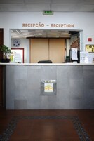 Un área de recepción con mostrador, un reloj y un cartel que dice 