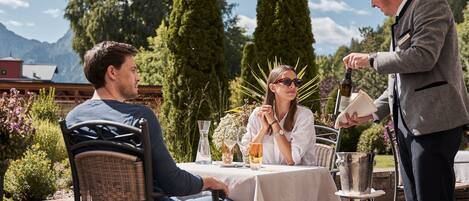 A table set outdoors with a person pouring a drink.
