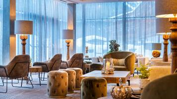 Un vestíbulo espacioso con ventanas amplias, asientos confortables e iluminación elegante.