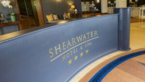 A reception desk with the name "Shearwater Hotel & Spa" and three stars. - Shearwater Hotel & Spa (Ballinasloe)