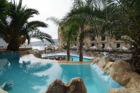 Una piscina al aire libre de temporada, sombrillas