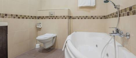 A bathroom with a bathtub, toilet, and shower.