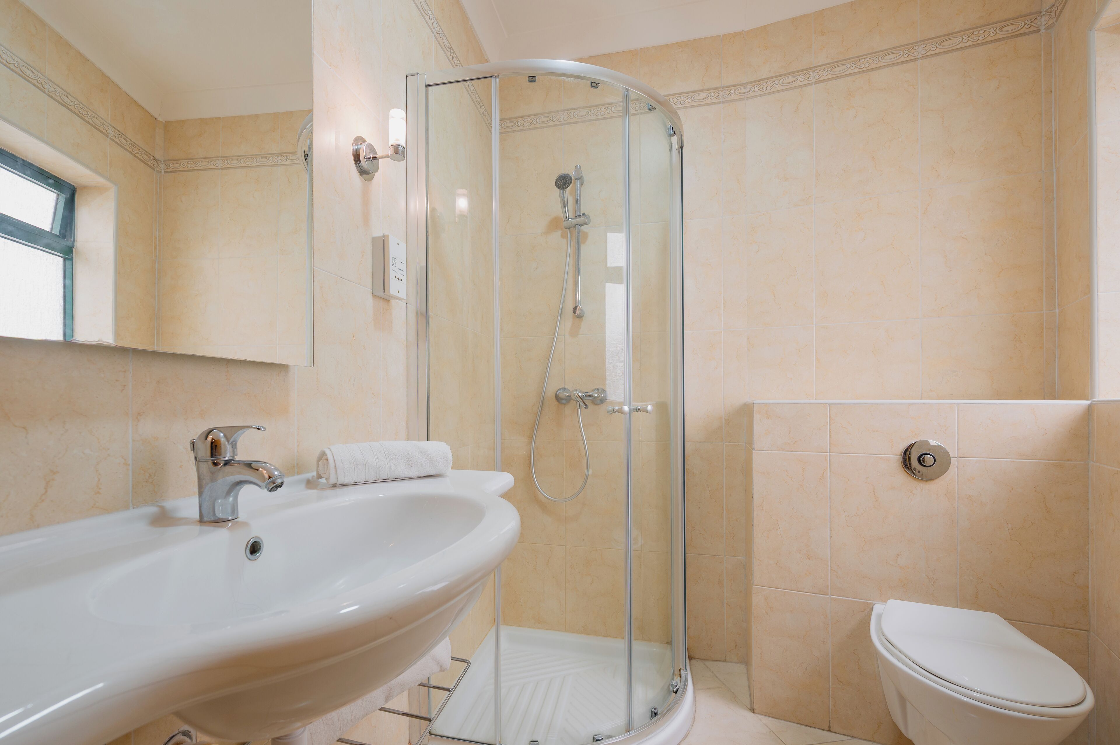 Ein Badezimmer mit Duschkabine, Waschbecken und Toilette.