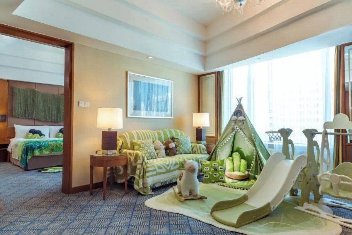 A hotel room with a bed, a sofa, a chair, and a window.
