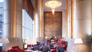 A spacious lobby with red and blue seating, large columns, and a grand chandelier. - Shangri-La Baotou (Baotou)