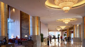 A spacious lobby with multiple chandeliers, a reception desk, and seating areas. - Shangri-La Baotou (Baotou)