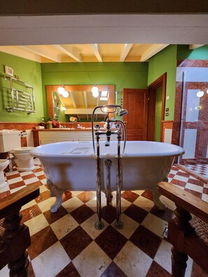 A bathroom with a checkered floor, a freestanding bathtub, a mirror with lights, and a towel rack. - Resort Locanda San Verolo Boutique Hotel (Costermano sul Garda)