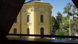 Keltainen rakennus, jossa on kupoli ja kaarevat ikkunat, nähtynä parvekkeelta.