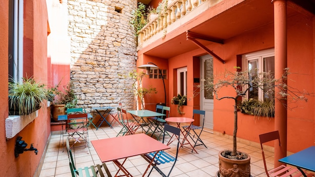 A courtyard with outdoor seating, stone walls, and potted plants. - Hotel Au Patio Morand (Lyon)